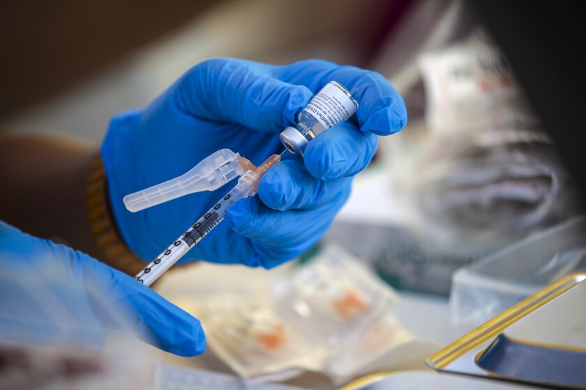 A dose of COVID-19 vaccine is prepared at a mobile vaccination clinic in Los Angeles on July 16. 
