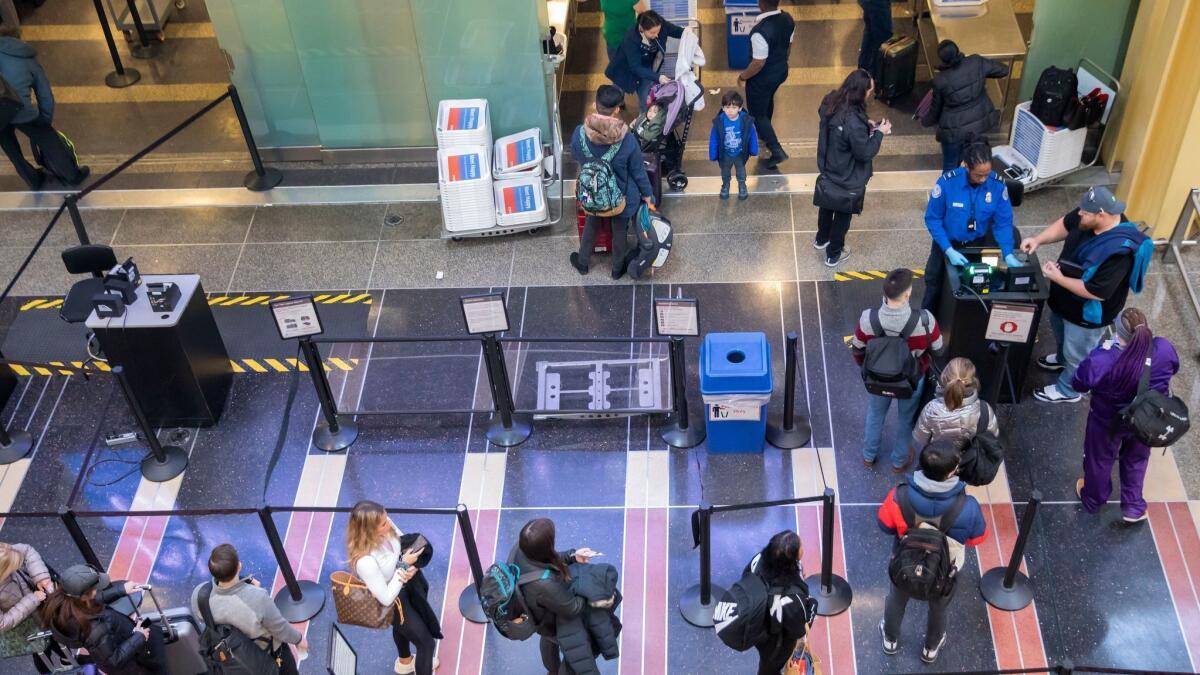 A TSA agent checks the identification of air travelers at Ronald Reagan Washington National Airport in Arlington, Va. on Jan. 7.