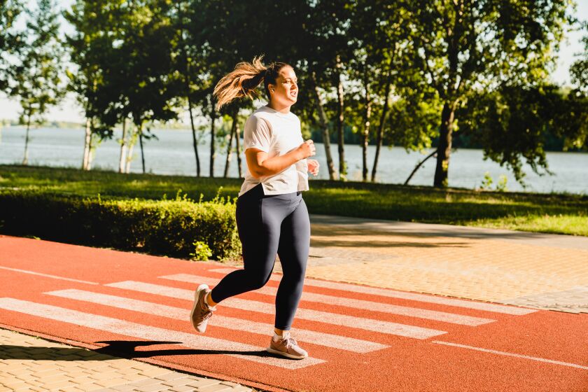 A woman jogs along an outdoor track.