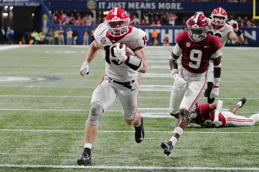 Georgia tight end Brock Bowers (19) runs into the end zone for a touchdown against Alabama defensive back Jordan Battle (9) during the second half of the Southeastern Conference championship NCAA college football game, Saturday, Dec. 4, 2021, in Atlanta. (AP Photo/John Bazemore)