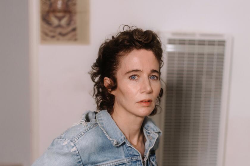 Miranda July, with short curly brown hair and a distressed denim jacket, looks into the camera.