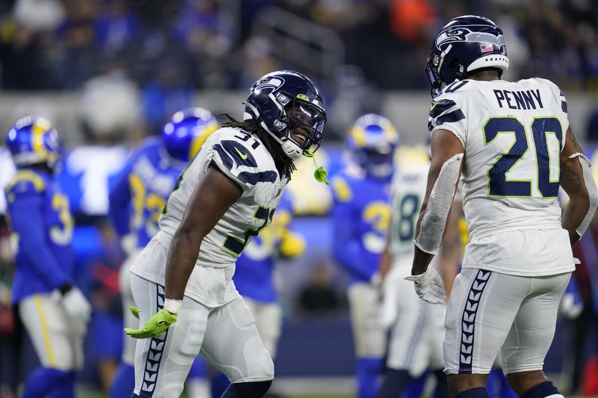 Seattle Seahawks running back DeeJay Dallas celebrates his rushing touchdown with running back Rashaad Penny.