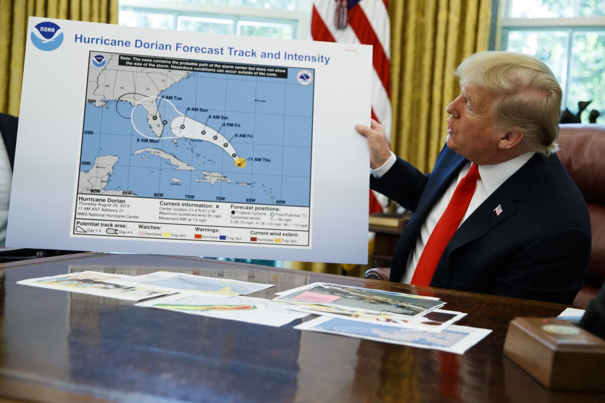 President Trump holds a chart as he talks with reporters after receiving a briefing on Hurricane Dorian in the Oval Office on Wednesday.