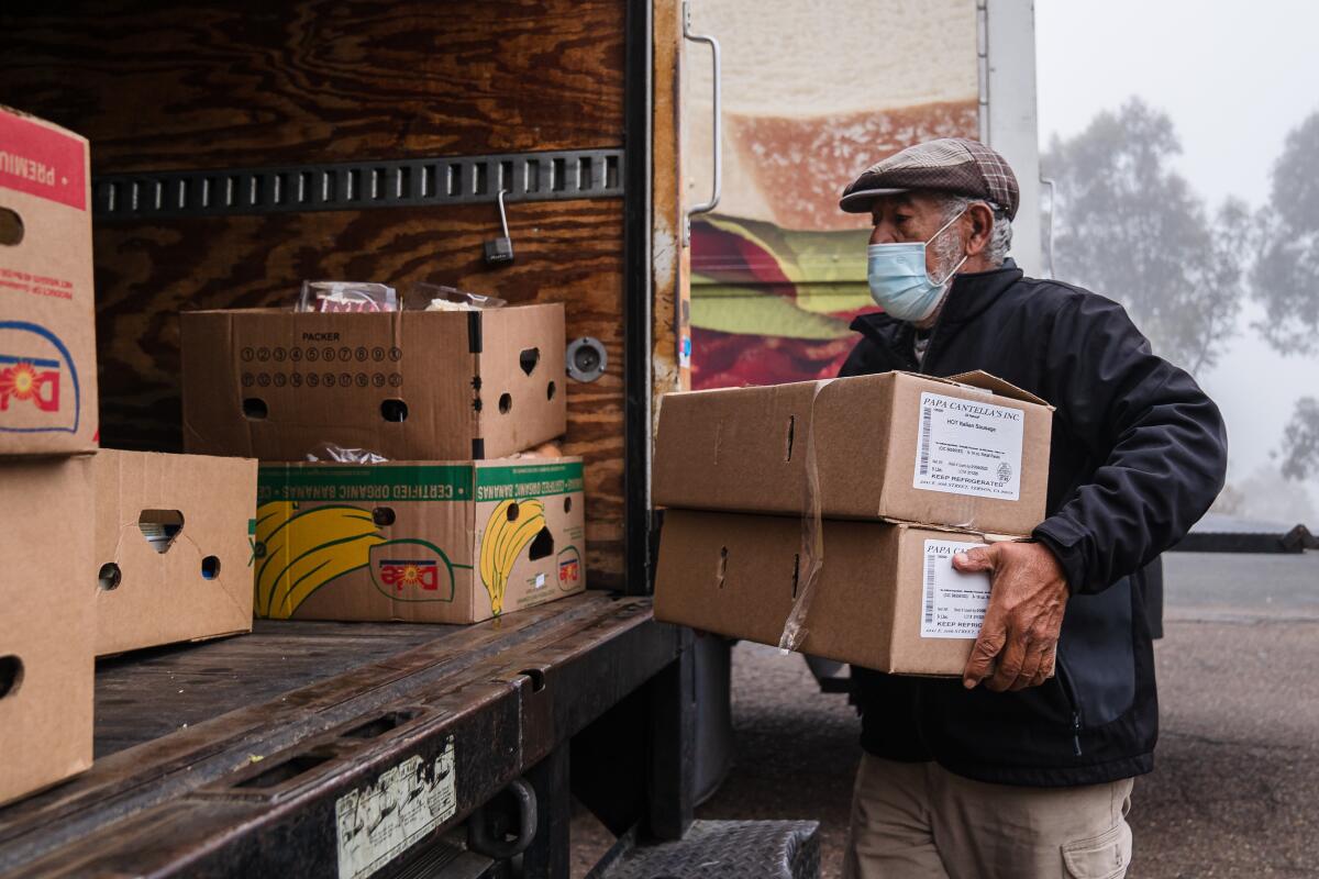 Victor Quinonez loads boxes of unused food onto a truck at Vons in South Bay on January 7, 2022.