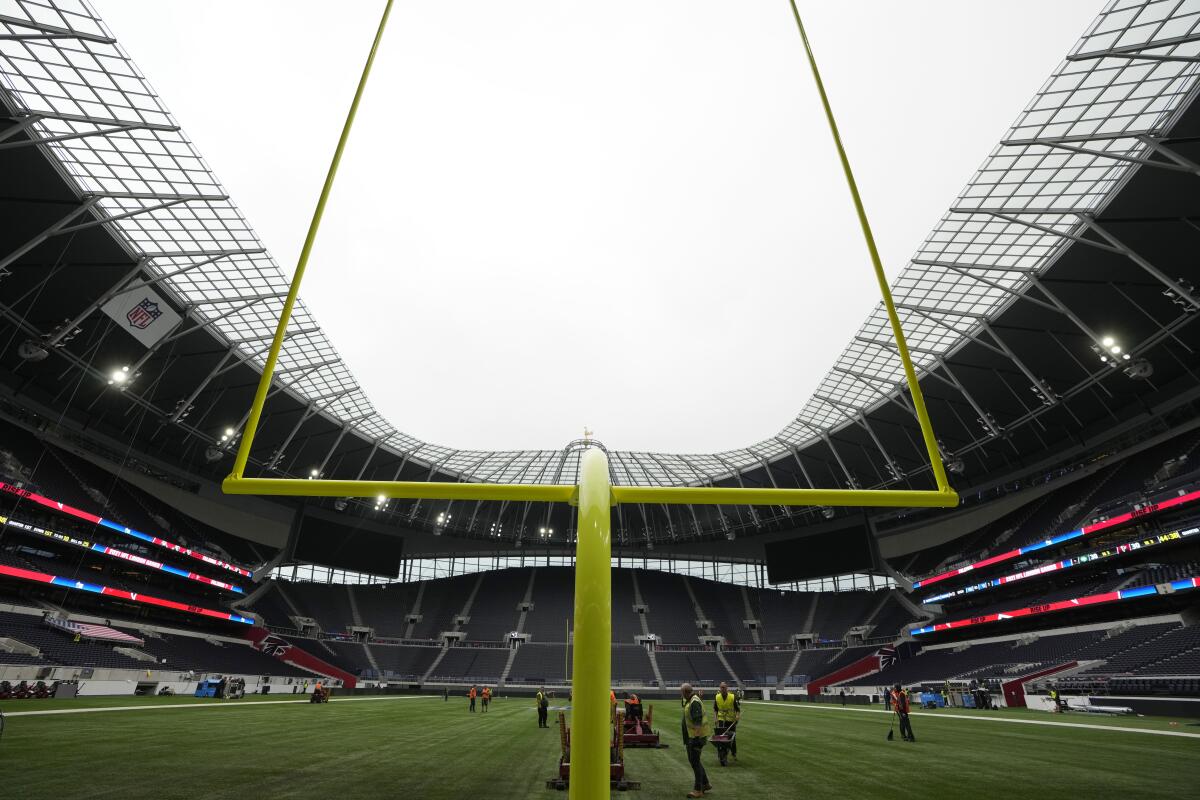 Workers prepare the pitch in preparation to host NFL at the Tottenham Hotspur Stadium in London, Thursday, Oct. 7, 2021. After a one-year hiatus due to the pandemic, the NFL returns to London on Sunday when the Atlanta Falcons play the New York Jets at Premier League club Tottenham’s $1.6 billion facility (AP Photo/Kirsty Wigglesworth)