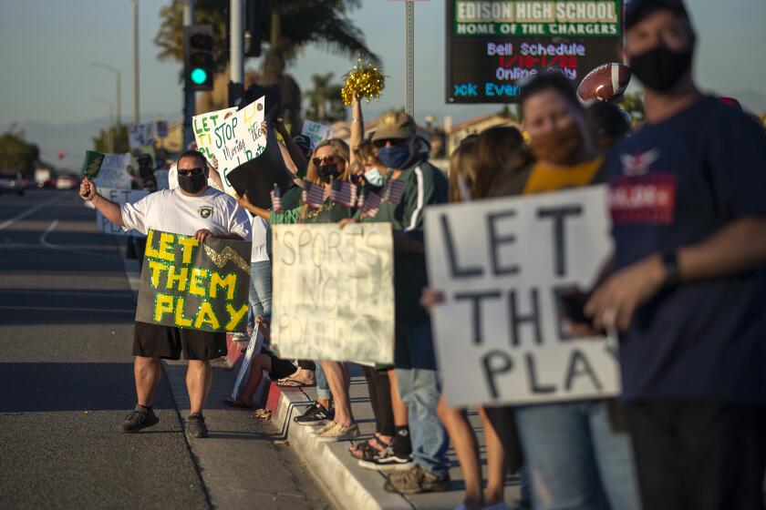 Mike Pino, left, and others participate in a "Let Them Play" rally at Edison High School on Friday, January 15.