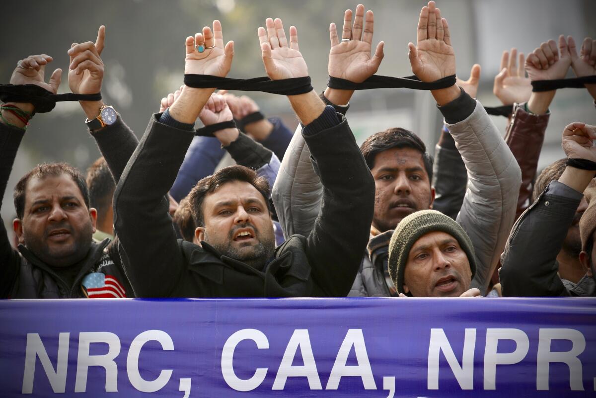 Indians raise their tied hands and shout slogans during a protest against a citizenship law.