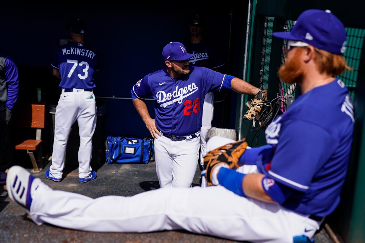 Dodgers teammates (from left) Zach McKinstry, Tyler White and Justin Turner stand in the dugout before Sunday's spring training exhibition game.