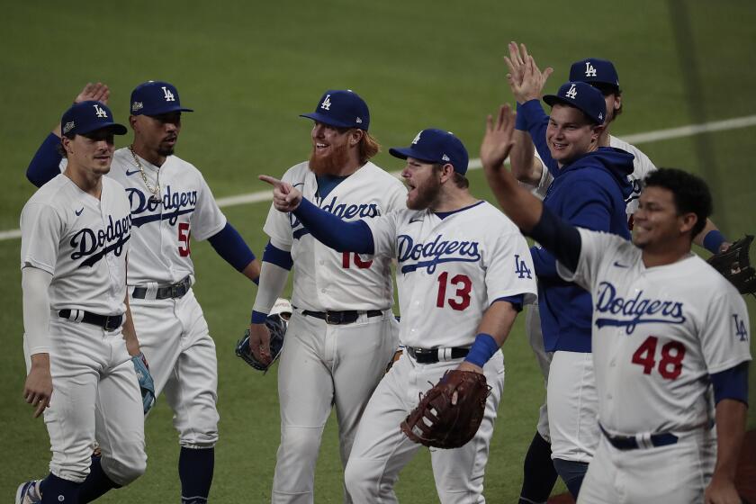 Arlington, Texas, Wednesday, October 7, 2020. Dodgers players react to Padres third baseman Manny Machado who expressed his displeasure with their celebration after Cody Bellinger made a homer saving catch on a Fernando Tatis Jr. drive during game two of the NLDS at Globe Life Field. (Robert Gauthier/ Los Angeles Times)