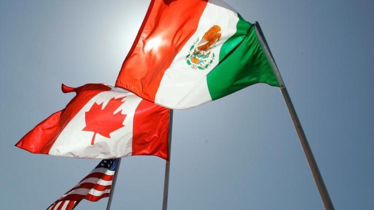 Las banderas nacionales de los Estados Unidos, Canadá y México. El tratado de Libre Comercio de América del Norte (NAFTA) eliminó las barreras comerciales entre los tres países (Judi Bottoni / Associated Press).