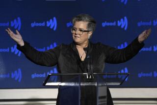 Rosie O'Donnell raises arms in black blazer during speech at the 2019 GLAAD Media Awards at the New York Hilton Midtown