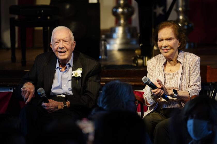 FILE- Former President Jimmy Carter and his wife former First Lady Rosalynn Carter sit together during a reception to celebrate their 75th anniversary Saturday, July 10, 2021, in Plains, Ga. In the year since Jimmy Carter first entered home hospice care, the 39th president has celebrated his 99th birthday, enjoyed tributes to his legacy and outlived his wife of 77 years. Rosalynn Carter, who died in November 2023 after suffering from dementia, spent just a few days under hospice. (AP Photo/John Bazemore, Pool, File)