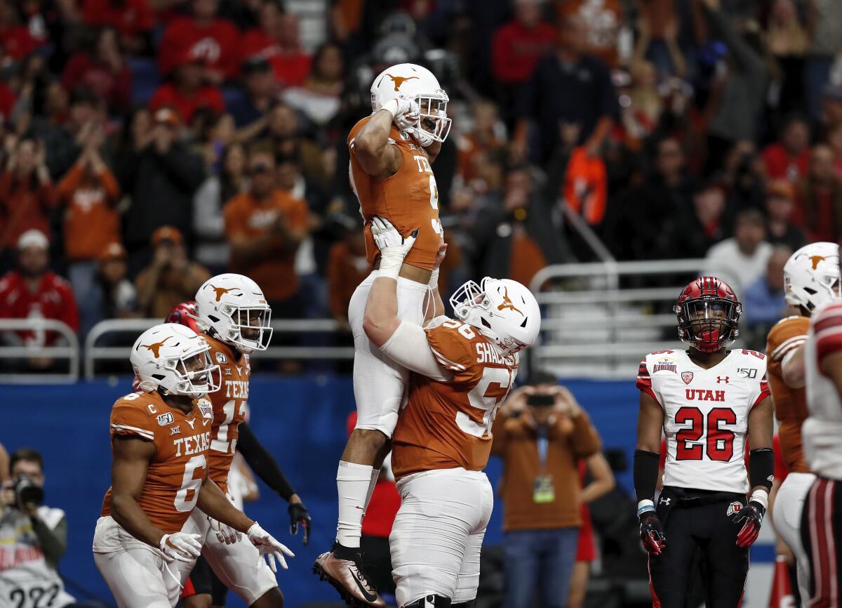 Zach Shackelford lifts Collin Johnson after scoring a touchdown against Utah during Texas' 38-10 victory in the Alamo Bowl. 
