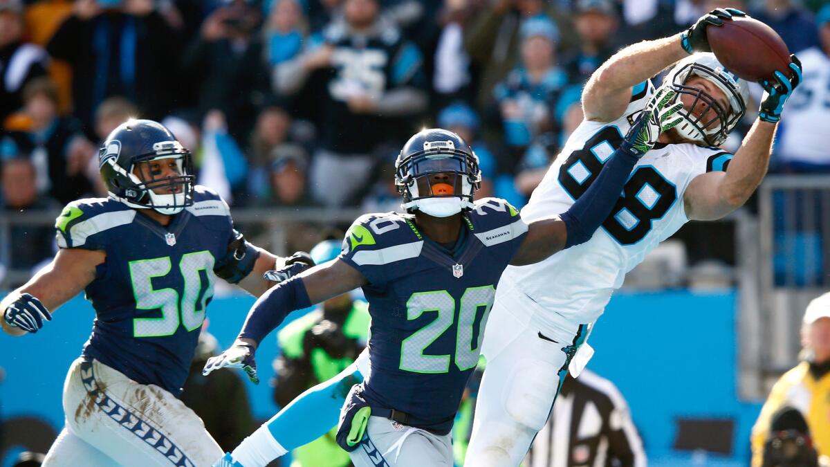 Panthers tight end Greg Olsen makes a 19-yard touchdown catch against Seahawks cornerback Jeremy Lane (20) and linebacker K.J. Wright (50) for a 31-0 lead in the second quarter Sunday.