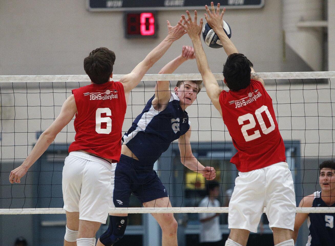 Crescenta Valley's Andrew Boyle hits a kill attempt into the block by Burroughs' Connor Burroughs and Jagger Green in a Pacific League boys' volleyball match at Crescenta Valley High School on Tuesday, April 9, 2019. Burroughs swept the match 3-0.