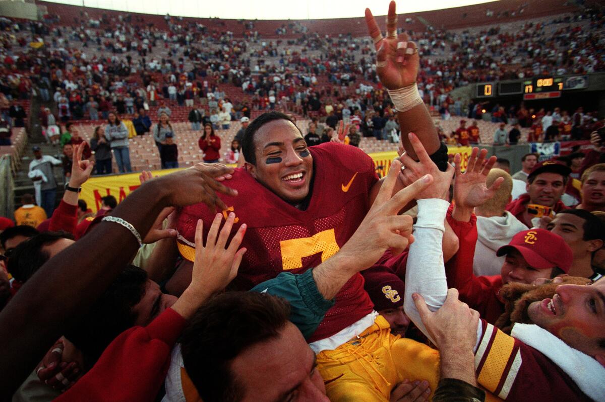 USC's Chad Morton is carried on the shoulders of fans after rushing for 143 yards in the Trojans' victory over UCLA at the Coliseum on Nov. 21, 1999.