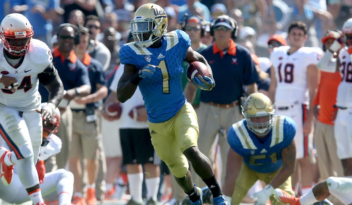 UCLA Bruins running back Soso Jamabo carries the ball against the Virginia Cavaliers at the Rose Bowl on Saturday.