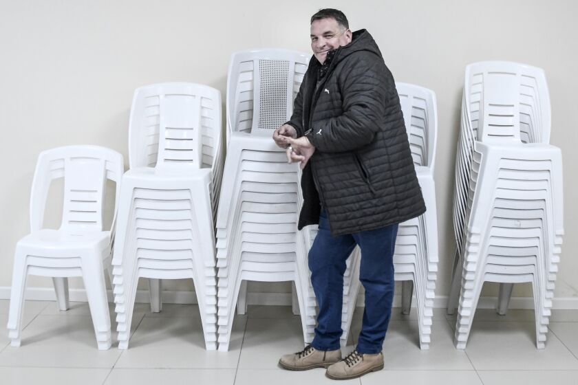 Alejandro Astesiano, body guard for presidencial candidate Luis Lacalle Pou, stands on the sidelines of Pou's campaign rally at the headquarters of the "Federation of Laborers and Drink Workers, FOEB, in Montevideo, Uruguay, Monday, Oct. 14, 2019. Astesiano has been under investigation for the last two months of 2022, for falsifying passports. (Javier Calvelo/adhocFOTOS via AP)