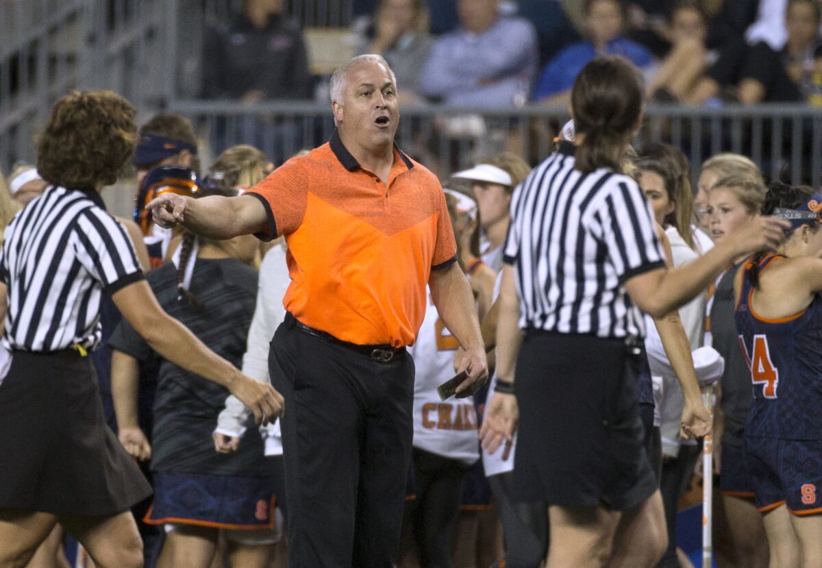 FILE - Gary Gait, center, at the time Syracuse women's lacrosse coach, talks with officials during the first half of a semifinal in the NCAA Division I women's lacrosse tournament against Maryland, May 22, 2015, in Chester, Pa. Gait's first year as men's lacrosse coach at Syracuse has been a challenge. With three games left in the regular season, the Orange (4-7, 1-2 Atlantic Coast Conference) are the only team with a losing overall record in the five-team ACC. That's uncharted territory for Syracuse, which has had only one losing season since 1975, 5-8 in 2007 under John Desko. (AP Photo/Chris Szagola, File)