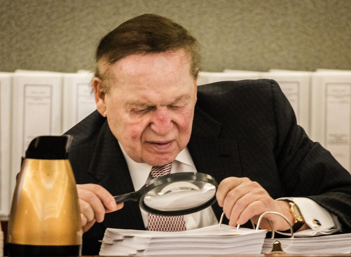 Sheldon Adelson, the billionaire casino developer, reads a deposition in April in a wrongful termination case. Adelson has shown a willingness to spend freely on the candidate of his choosing, and GOP hopefuls are lining up for his support.