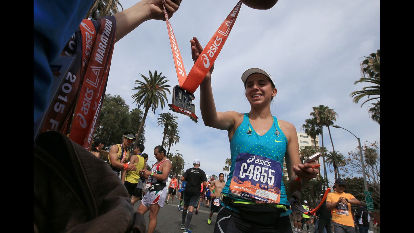 Runners in the 30th Los Angeles Marathon are awarded medals at the finish line in Santa Monica.