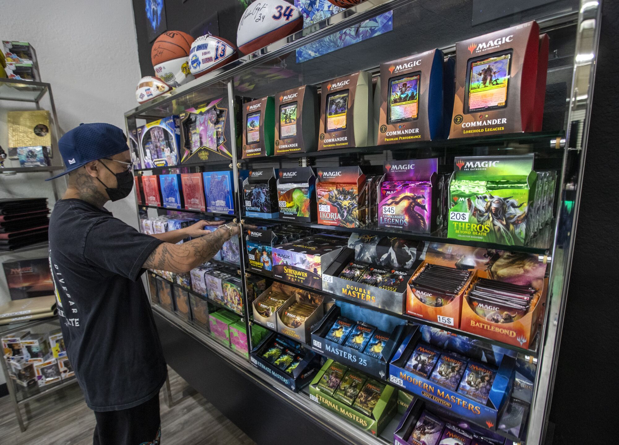 Cash Cards Unlimited shop manager Chris Cyre stocks a shelf inside the store located in Westlake Village.