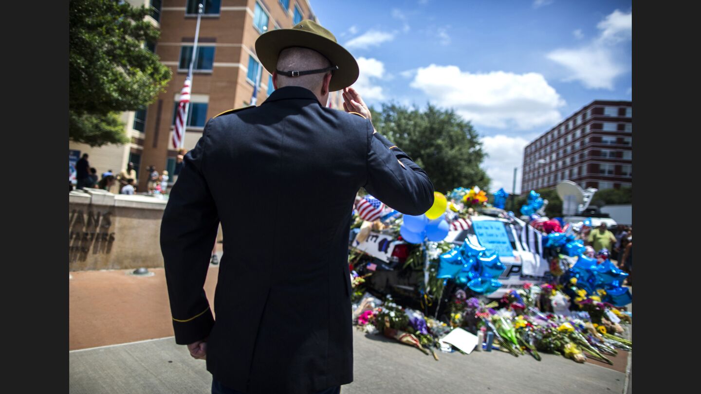 Retired Army Sgt. Chandler Davis, pays his respects at the growing memorial in front of the Dallas Police Headquarters.
