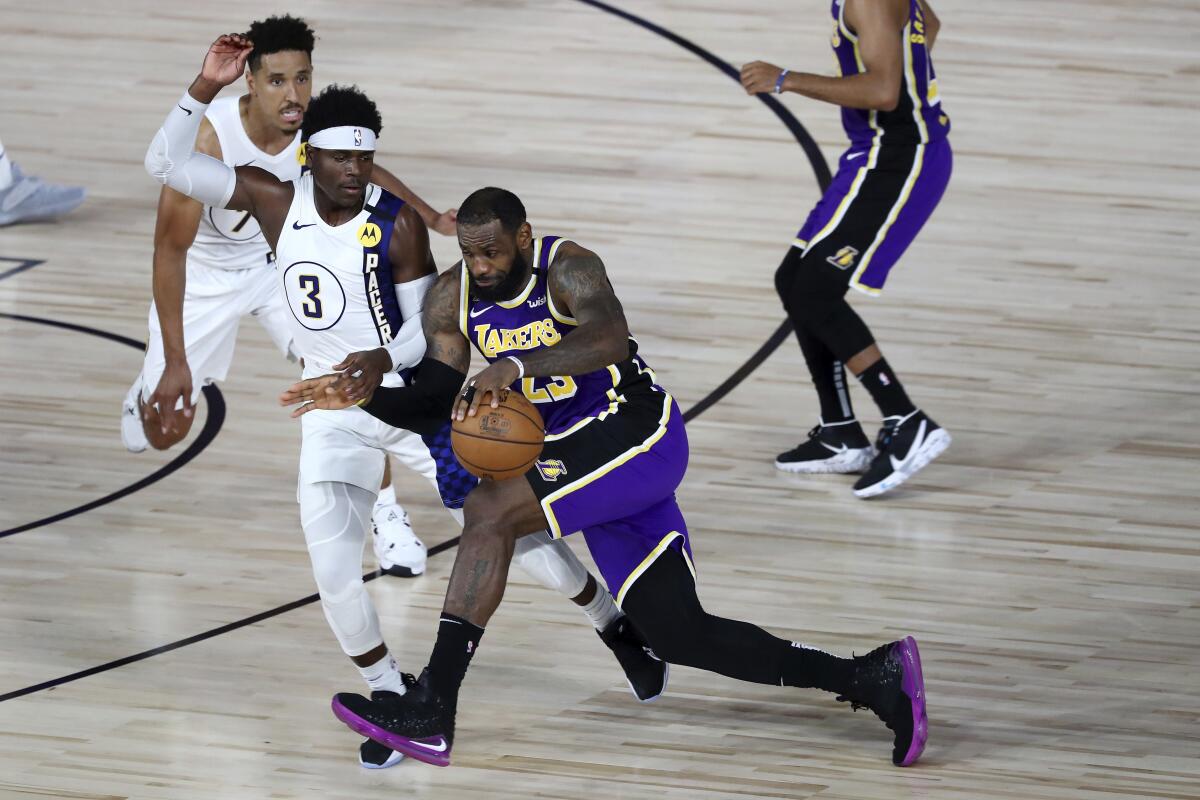 The Lakers' LeBron James drives against the Pacers' Aaron Holiday during the fourth quarter.