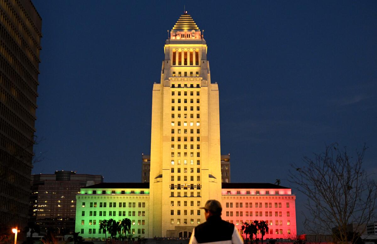 LA City Hall at night, lit up red, yellow and green. 