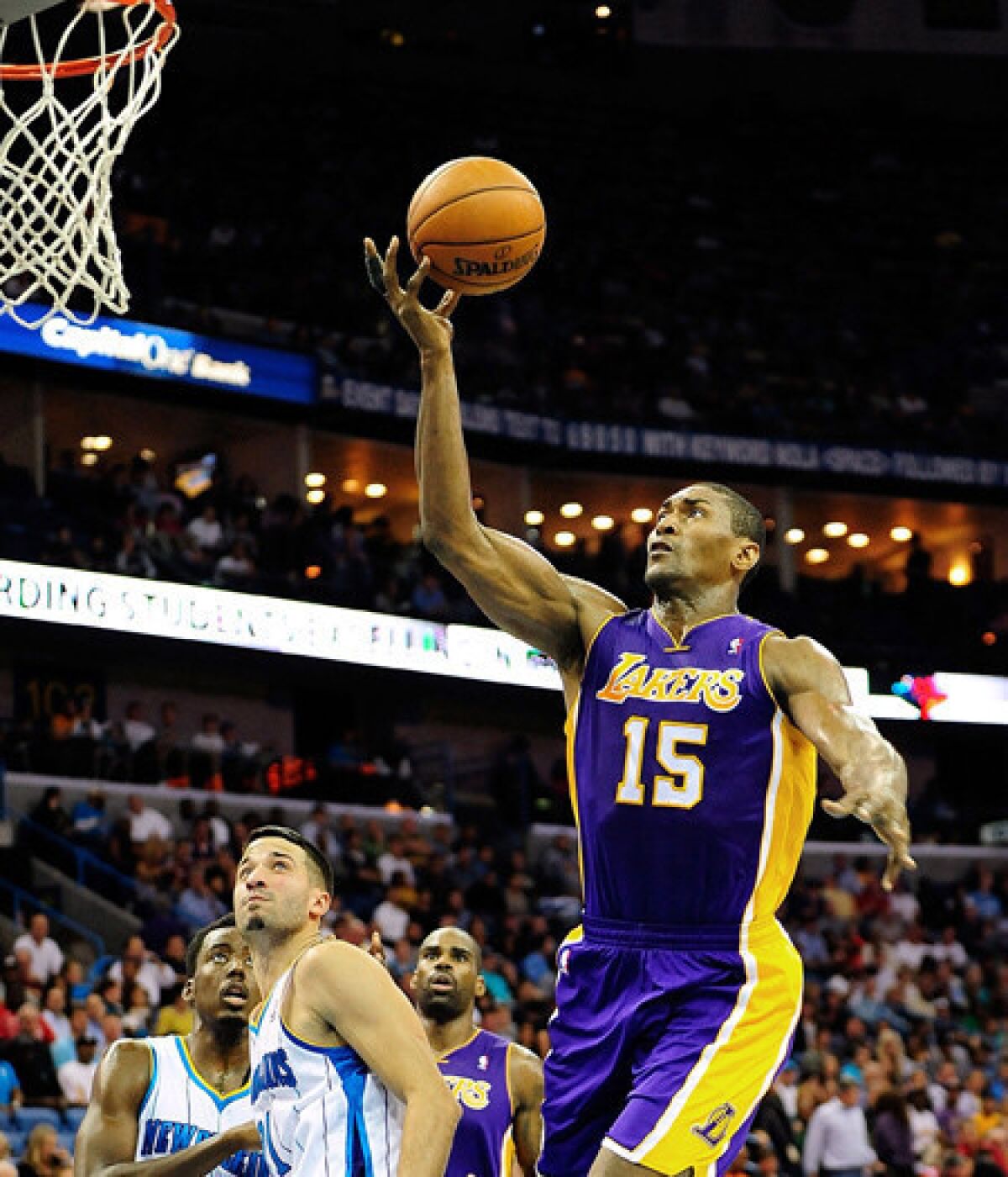 Lakers forward Metta World Peace drives past Hornets guard Greivis Vasquez for a layup Wednesday night in New Orleans.