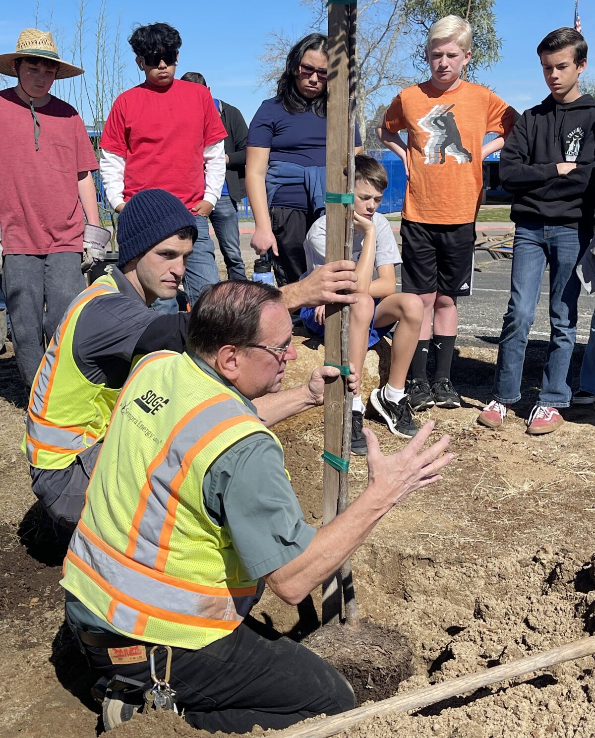 Davey Resource Group Arborist Nathan Davila, left, and Jimmie Webb of SDG&E help Ramona students plant trees.