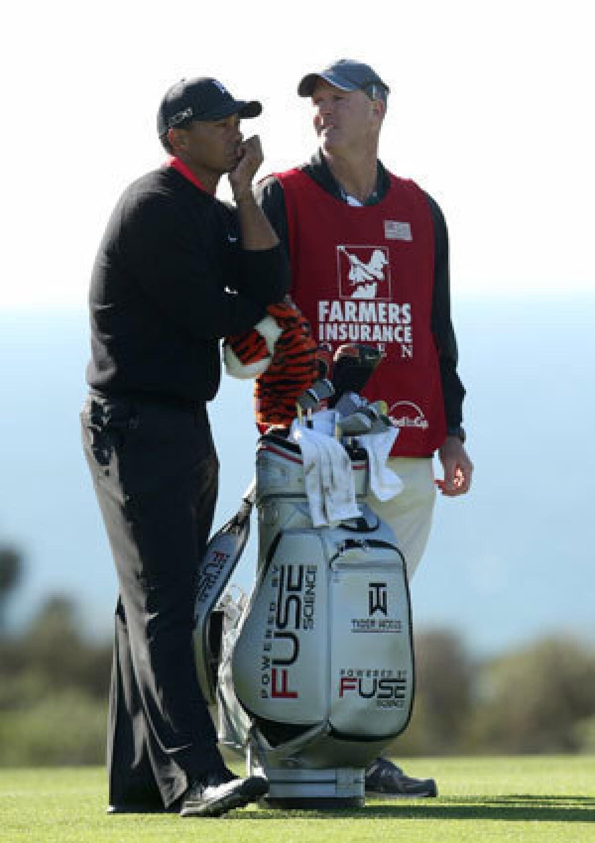 Tiger Woods waits with caddie Joe LaCava on the 17th hole during the final round of the Farmers Insurance Open at Torrey Pines.