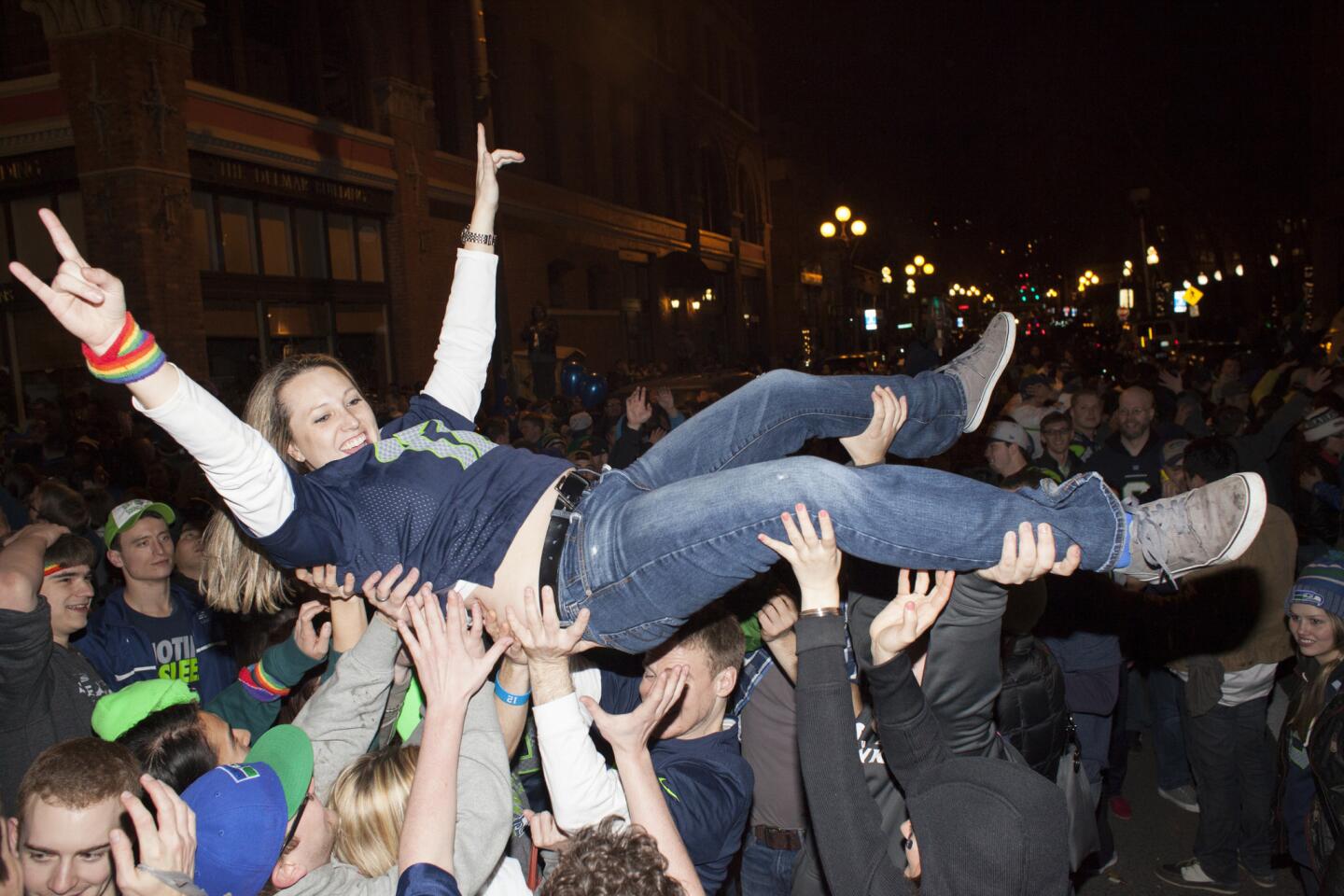 Seattle Seahawks fan Sara Hatfielf surfs through the crowd in the middle of 1st Avenue on Sunday night in Seattle. Hundreds of people flooded the streets of downtown Seattle after the Seahawks defeated the Denver Broncos in the Super Bowl.