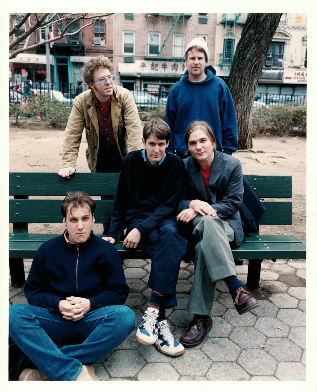 Pavement members pose on a park bench.