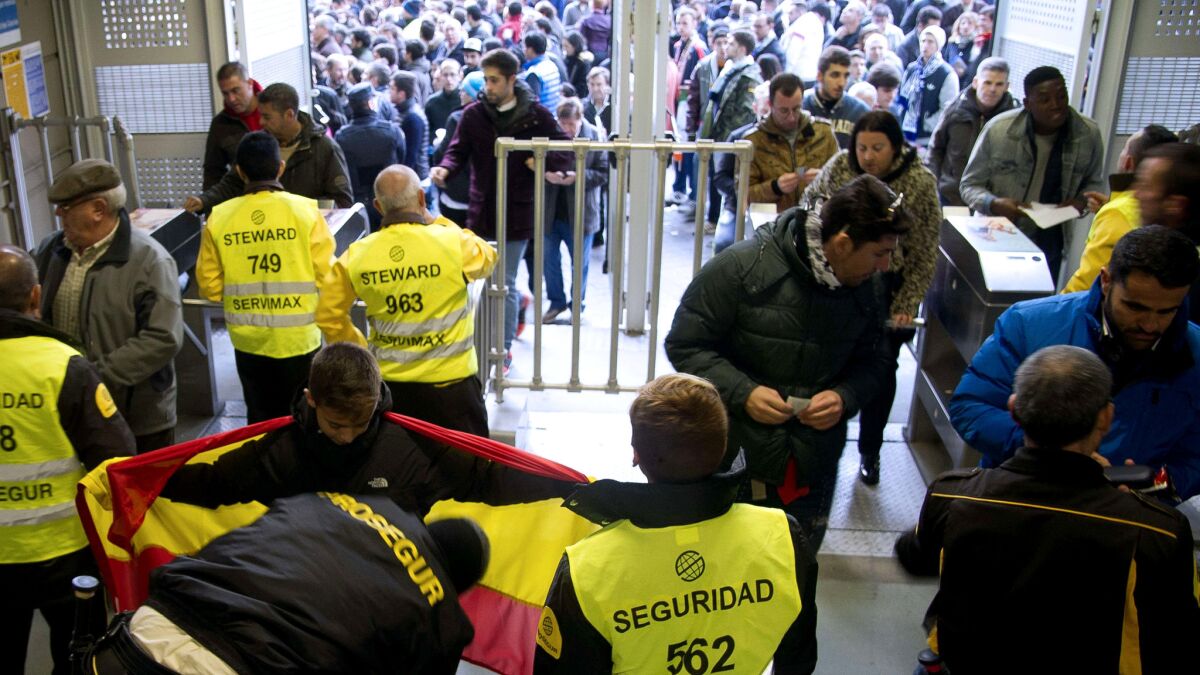 Security personnel frisk supporters before the Spanish league game between Real Madrid and Barcelona at the Santiago Bernabeu Stadium on Saturday.