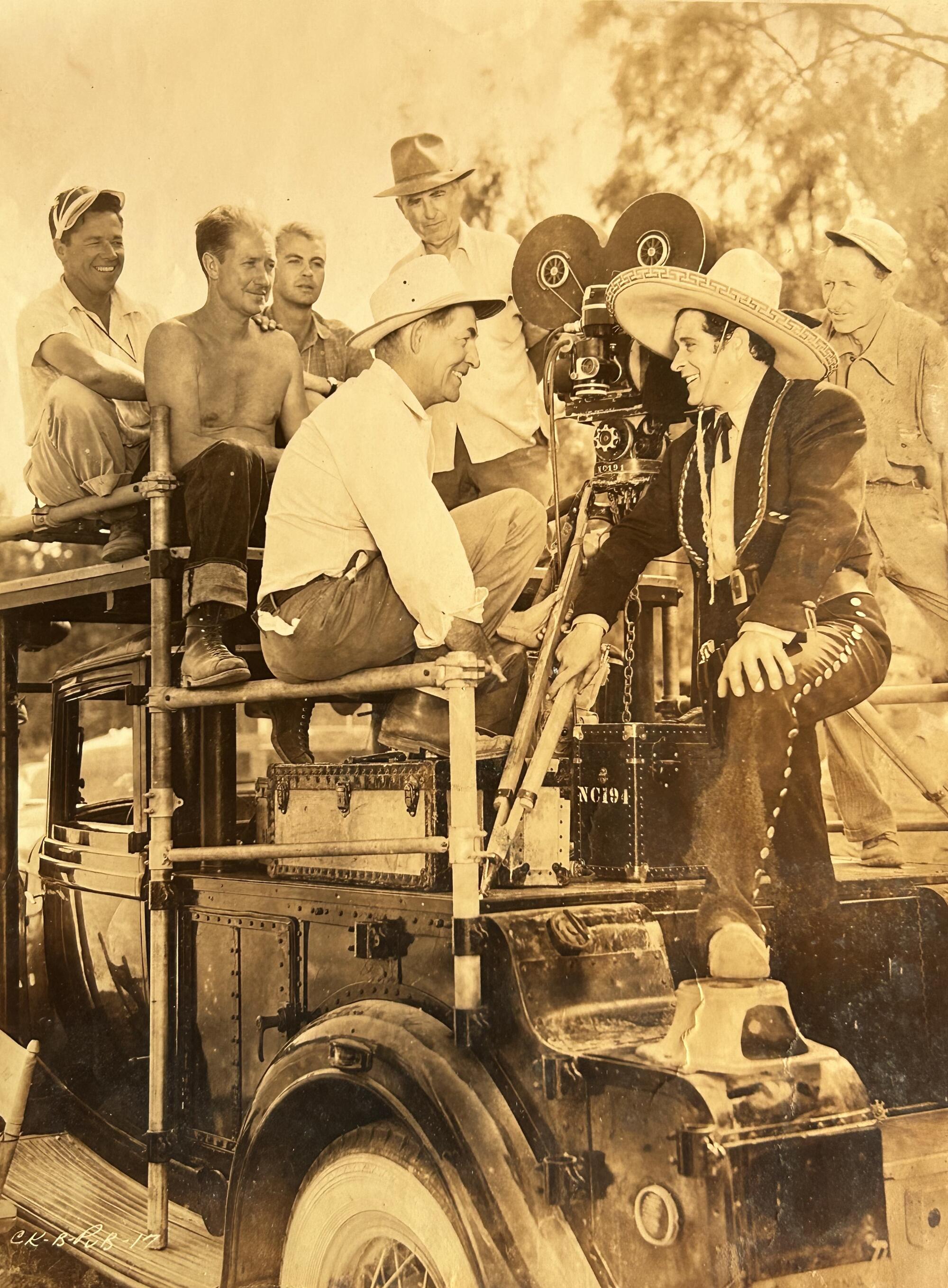 A movie director talks to an actor in a charro costume in a photo from the early days of Hollywood