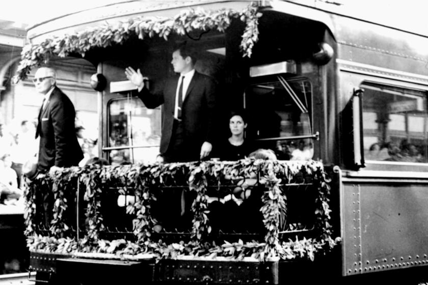 Sen. Edward M. Kennedy waves from the rear platform of the observation car 