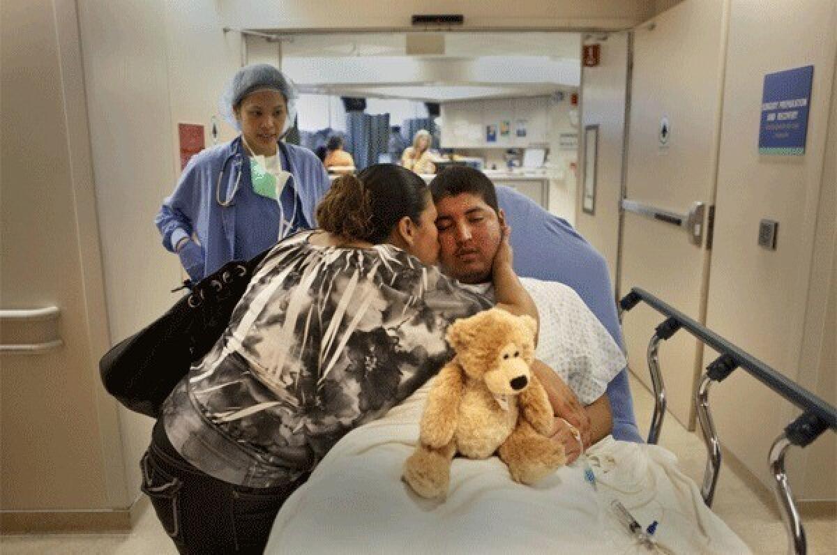 In the last moments before surgery, Valentina Gonzales kisses her son Jesus Garcia, 19, goodbye. Groggy from the anesthesia, Jesus is still clutching the teddy bear given to him by a nurse. The surgery lasted seven hours. Only a small amount of the tumor was removed and within a month after the surgery, the tumor had grown back.