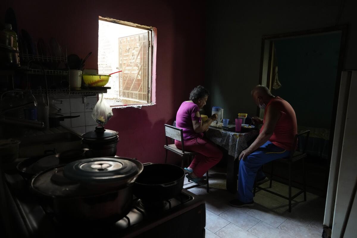 Los ancianos Maybel Sequera y Juan González almuerzan en su casa en el barrio de bajos ingresos de La Vega 