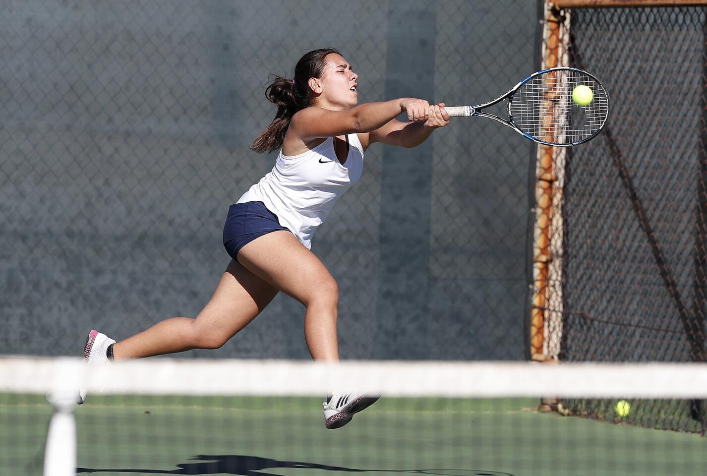 Crescenta Valley's Melika Seyed Mouhammad Lou leaps at an Arcadia return to hit it into play in a Pacific League girls' tennis match at Crescenta Valley High School on Tuesday, October 16, 2018.