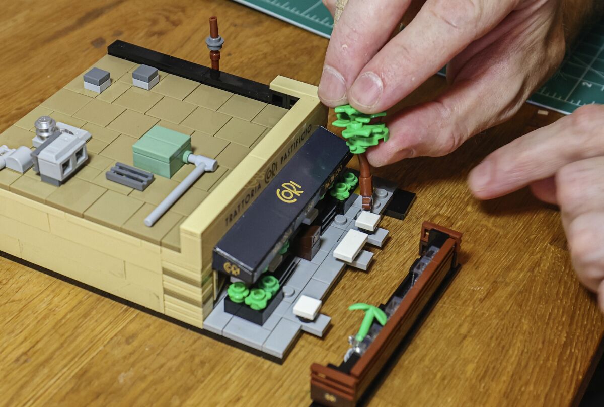 Lego artist Ben Smith works on his recreation of a North Park restaurant Cori Trattoria Pastificio at his North Park home