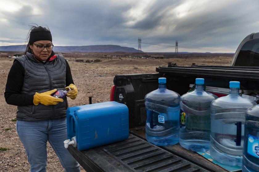 CAMERON, AZ - MARCH 28, 2020: Living without electricity or running water, Navajo Indian Shanna Yazzie made sure she carried hand sanitizer and fresh water on a trip to get supplies from family members near Phoenix during the coronavirus pandemic on the Navajo reservation on March 28, 2020 in Cameron, Arizona. She, her two children and elderly mother have been self-quarantining for the past two weeks fearing the virus and had her pantry was bare.(Gina Ferazzi/Los AngelesTimes)