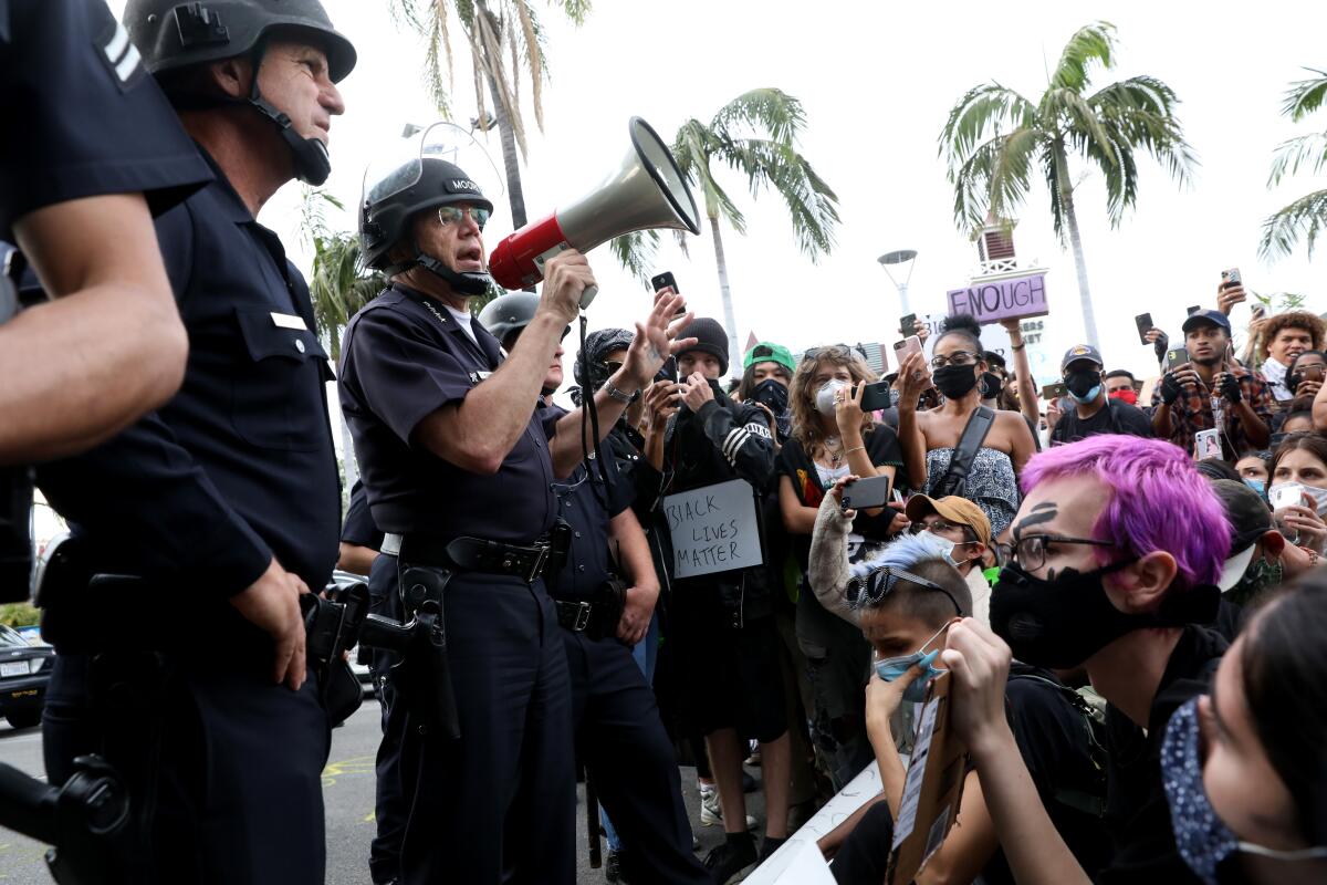 LAPD Chief Michel Moore addresses protesters through a bullhorn over the weekend in the Fairfax district.