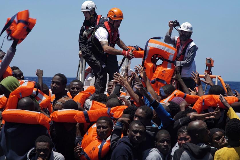 FILE - In this Thursday June 23, 2016 file photo, rescue workers disembark migrants from a dinghy in the Mediterranean Sea, rescued by members of the medical aid group Medecins Sans Frontieres (MSF) and the rescue group SOS Mediterranee Rescuers of SOS Mediterranee. Doctors Without Borders said Saturday, Aug. 12, 2017, it is temporarily suspending the activity of its rescue ship due to alleged threats from Libyaâs coast guard, which has increasingly become more aggressive in patrolling the waters off its coasts where human traffickers launch boats crowded with migrants desperate to reach Europe. (AP Photo/Bram Janssen, File)