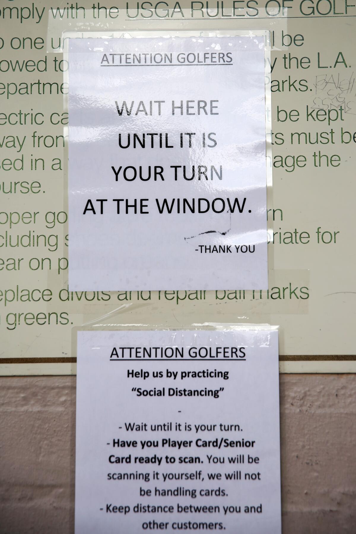 Signs at the counter at the Rancho Park Golf Course alert players to precautions taken to prevent the spread of the coronavirus.