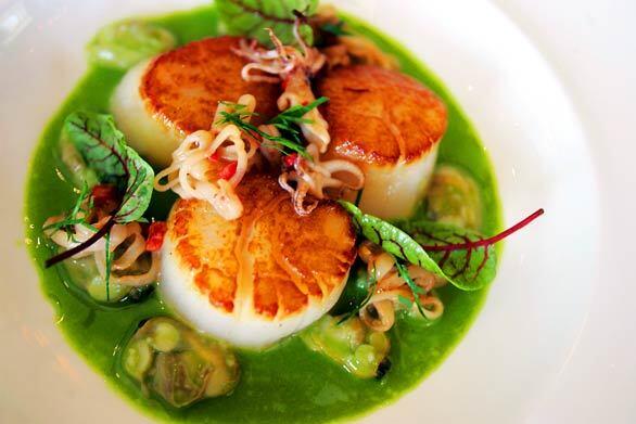 Sea scallops are paired with sauteed calamari in a clam parsley broth at Charlie Palmers newest venture  next to Bloomingdales at South Coast Plaza in Costa Mesa.