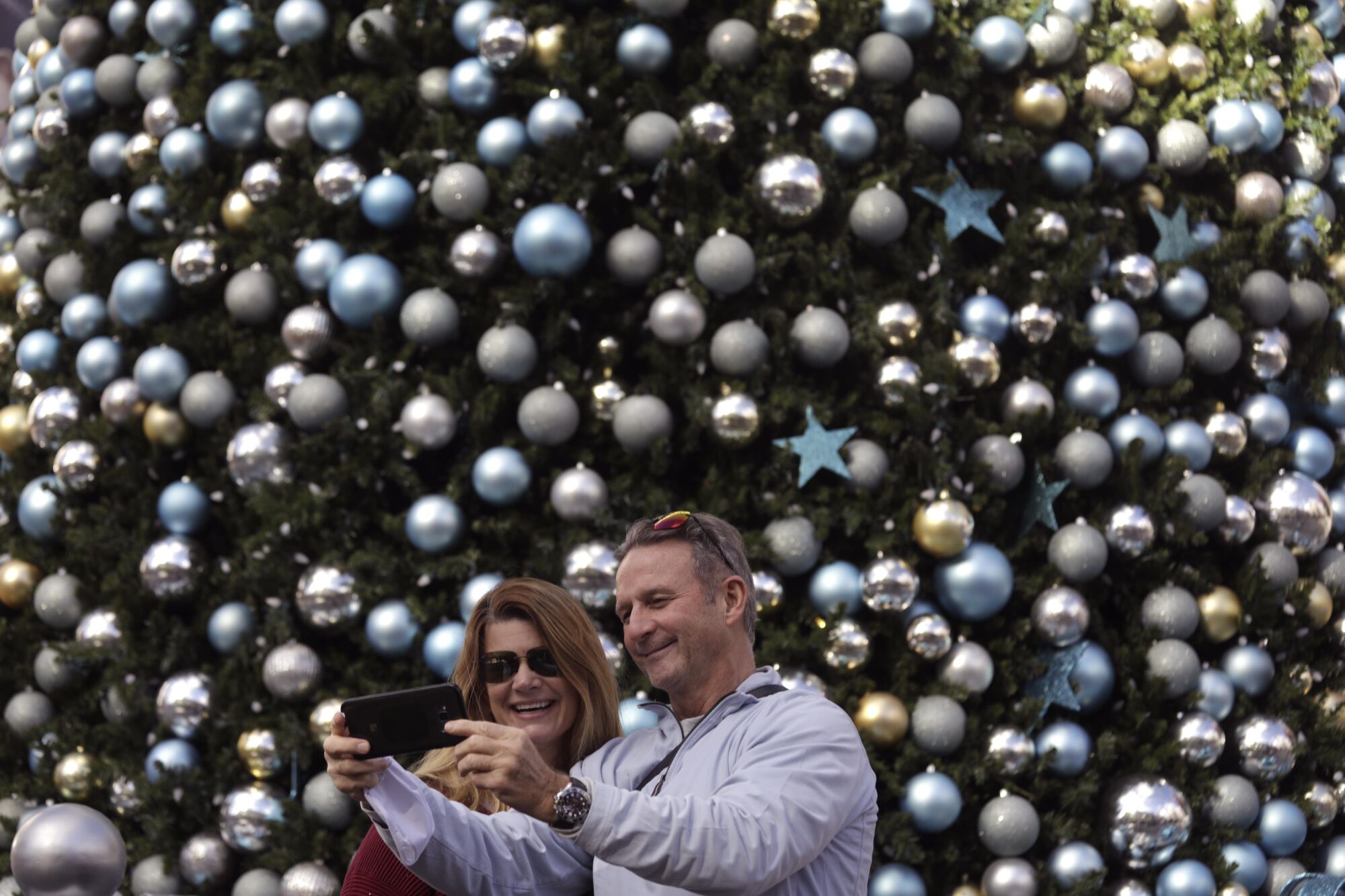 Rebecca and Michael Steele of Washington, D.C., take a selfie against  a Christmas tree at Universal City Walk