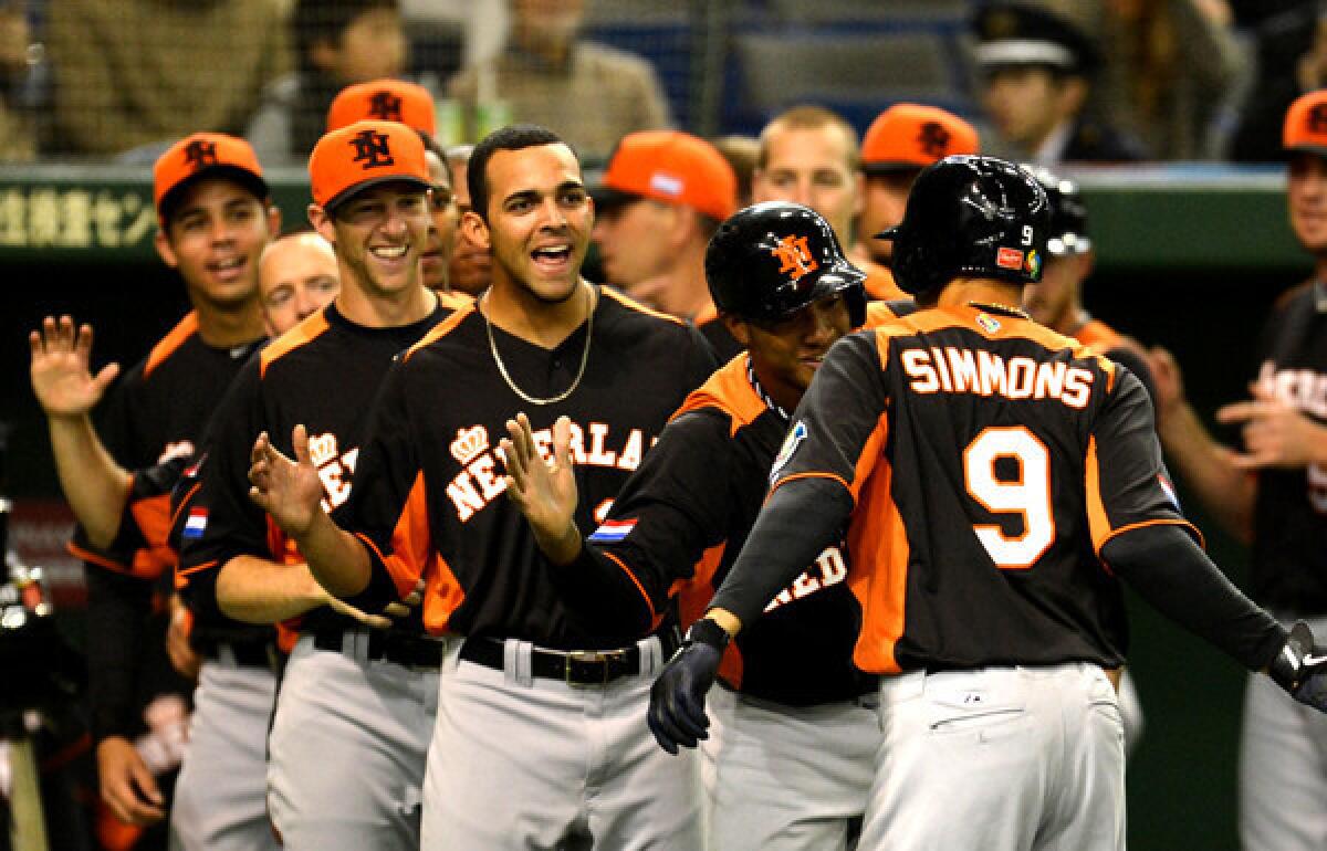 The Netherlands infielder Andrelton Simmons is congratulated by teammates after his solo homer against Japan during a pool-play game in the World Baseball Classic