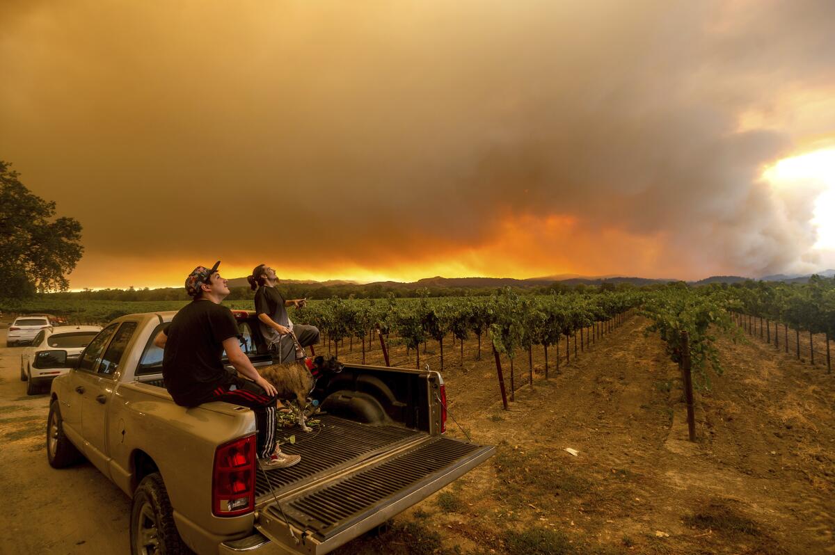 Thomas Henney and Charles Chavira watch a plume spread over Healdsburg, Calif., as the LNU Lightning Complex fires burn