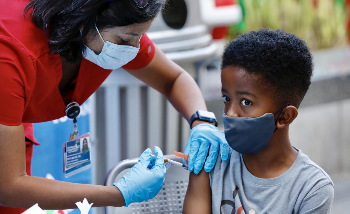 A 7-year-old receives a COVID-19 vaccine.